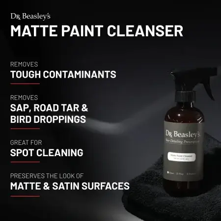 A 12 fl oz bottle of Matte Paint Cleanser placed on a matte grey hood.