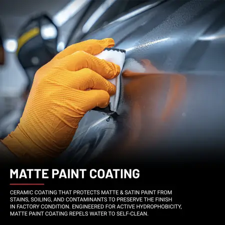 Hand in orange glove applies matte paint coating to matte grey Mercedes C63 AMG with yellow stripes.