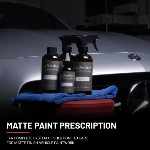 Four bottles of Matte Paint Prescription on a red chair in front of a matte grey Mercedes-Benz.