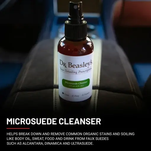 4 oz bottle of Microsuede Cleanser placed on a black Alcantara armrest console.