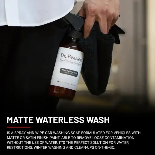 A man wearing a white shirt and black trousers holds a 12 fl oz bottle of Matte Waterless Wash.