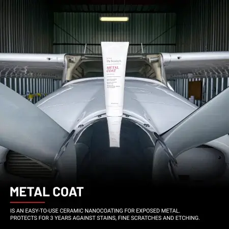 An 8 oz tube of Metal Coat positioned on the grey front fuselage of a plane.