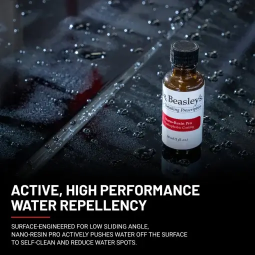 1 oz bottle of Nano-resin Pro placed on a black coated hood with water repellency effect.