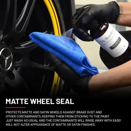 Matte Wheel Seal 12 fl oz bottle spraying onto a blue towel in front of matte black Mercedes wheel with yellow stripe.