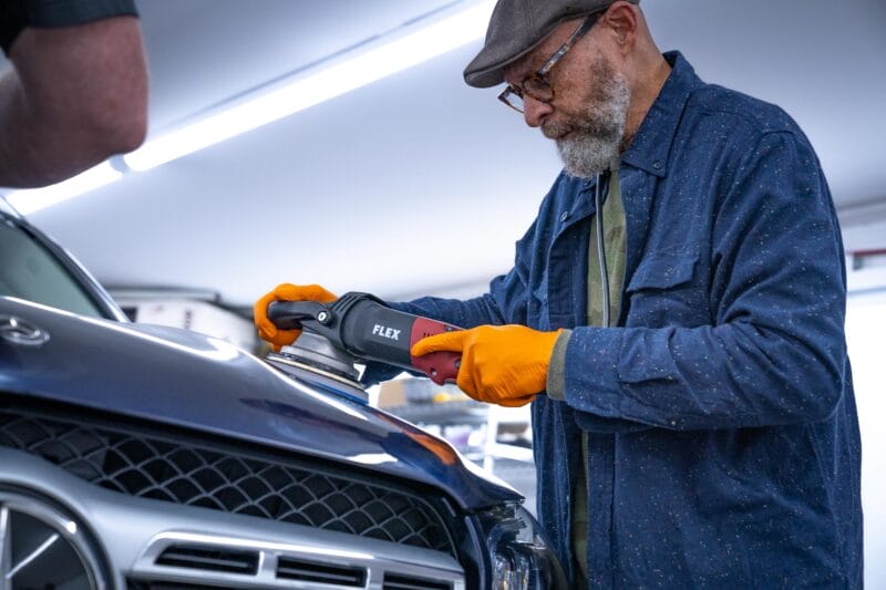 Detailer using an orbital on a Mercedes hood during The Future of Detailing class.