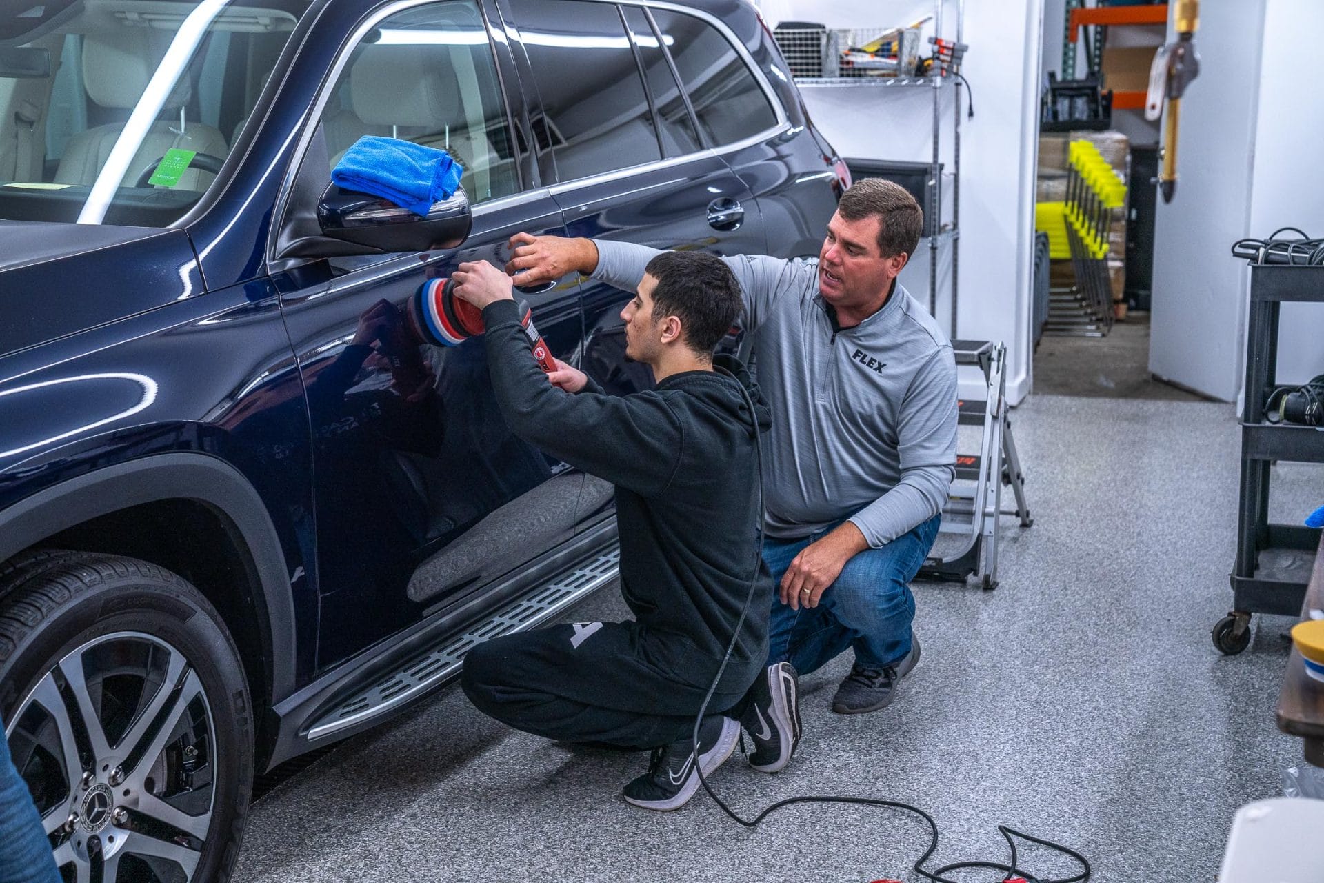 Chris Metcalf instructing student as they learn to paint correct a car.