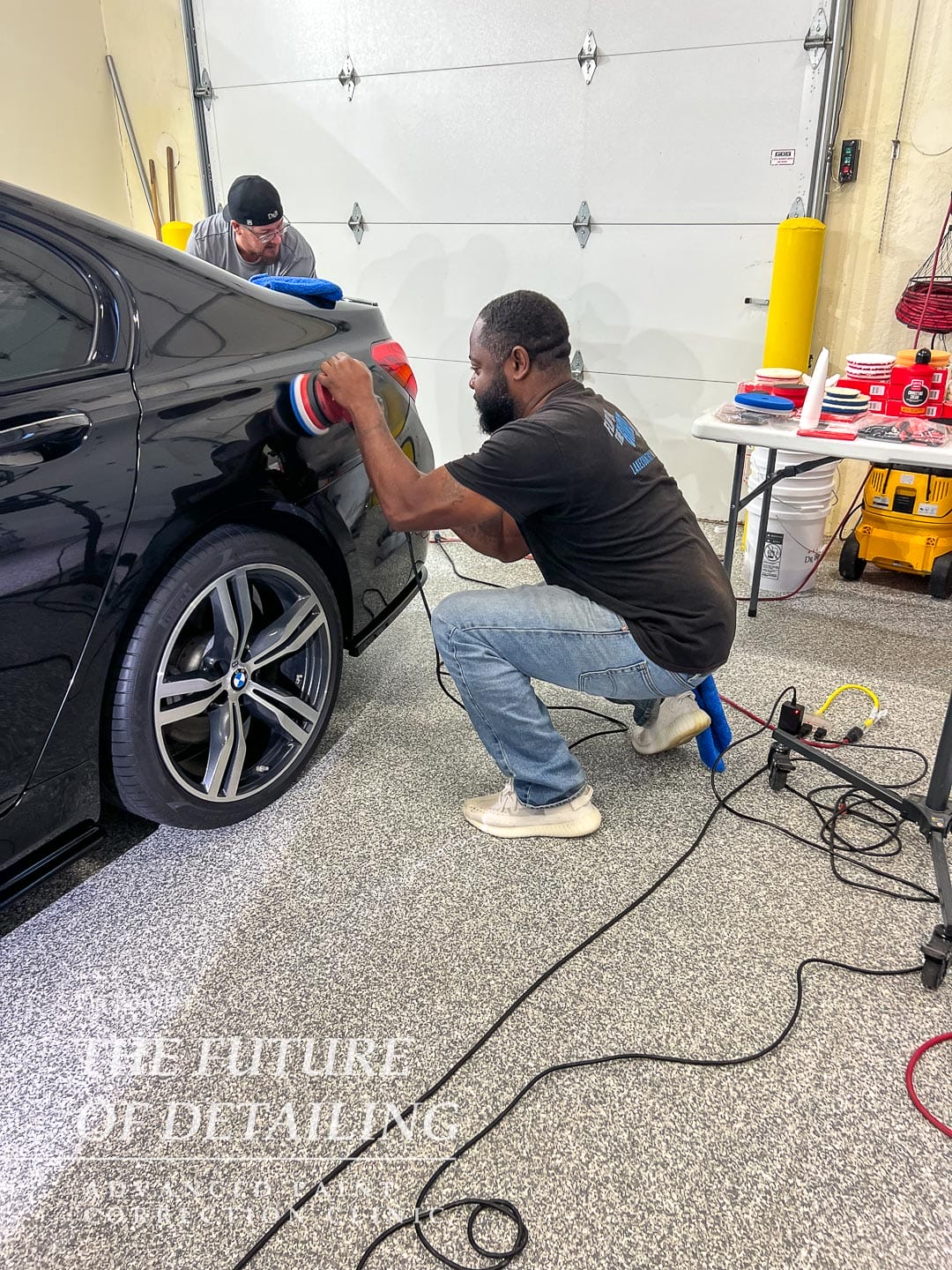 Student polishing the quarter panel on a BMW.
