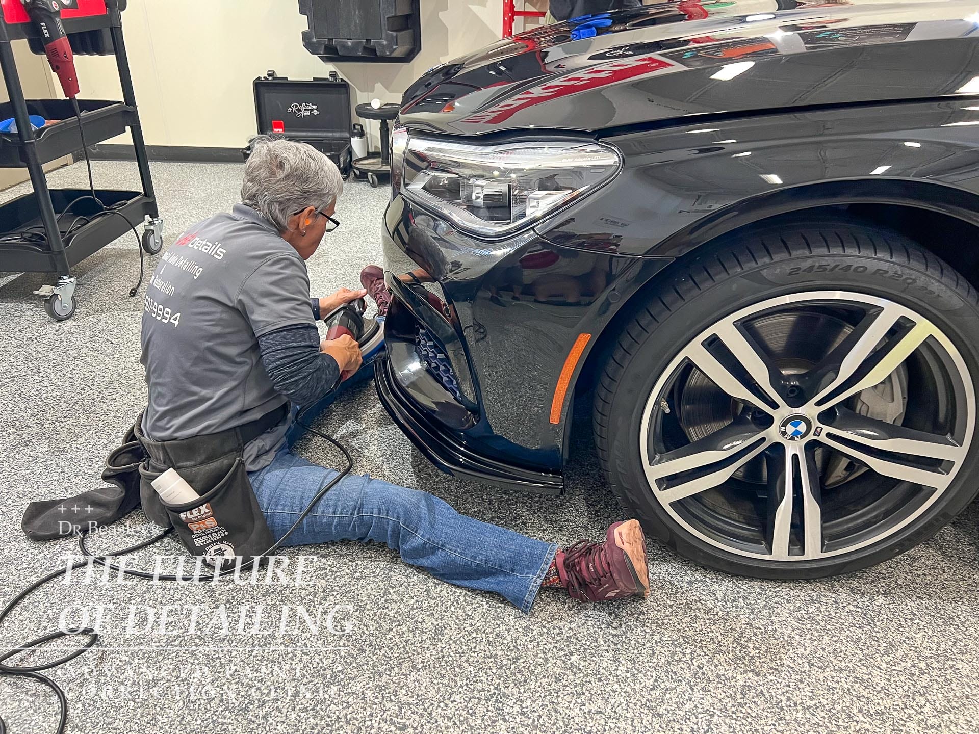 Student polishing the rocker panels on a BMW.