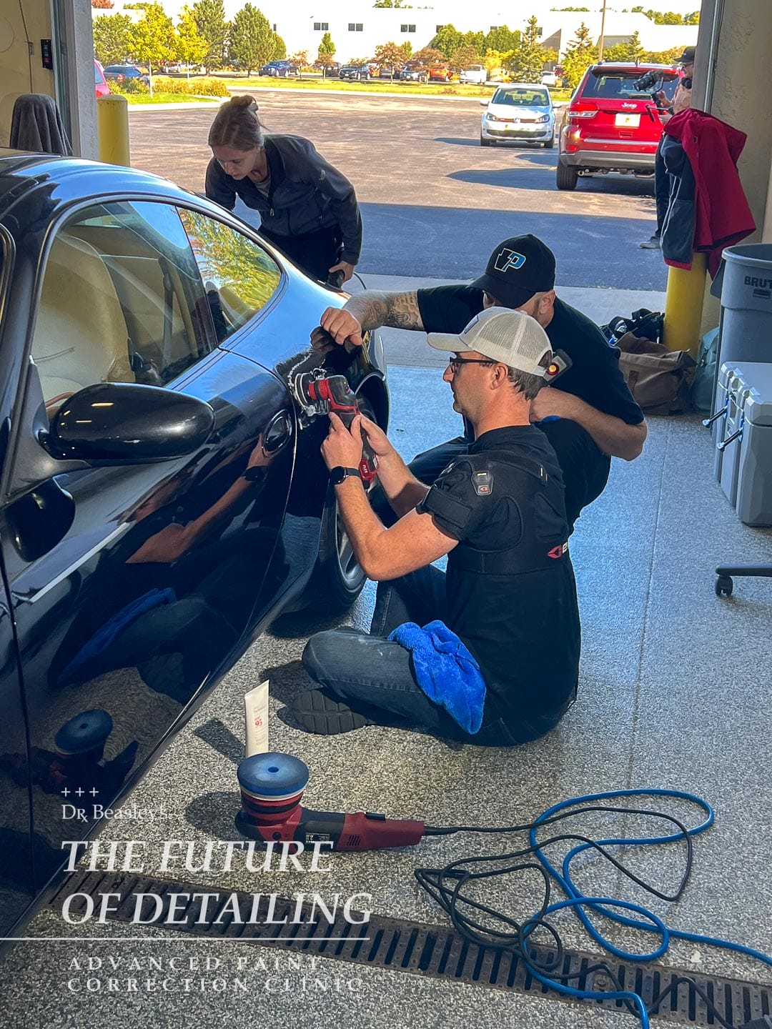 Instructor advising student polishing Porsche 911 quarter panel.