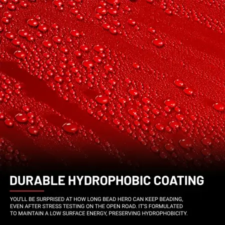 Close-up of a red surface with numerous water droplets beading on it, demonstrating the effectiveness of a hydrophobic coating