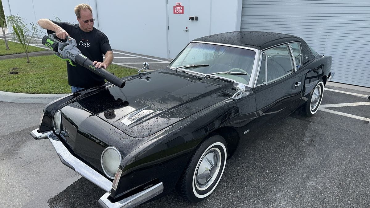Blow drying a black car after washing