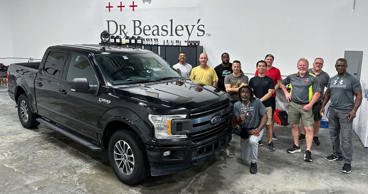 Class posing with truck for detailing class