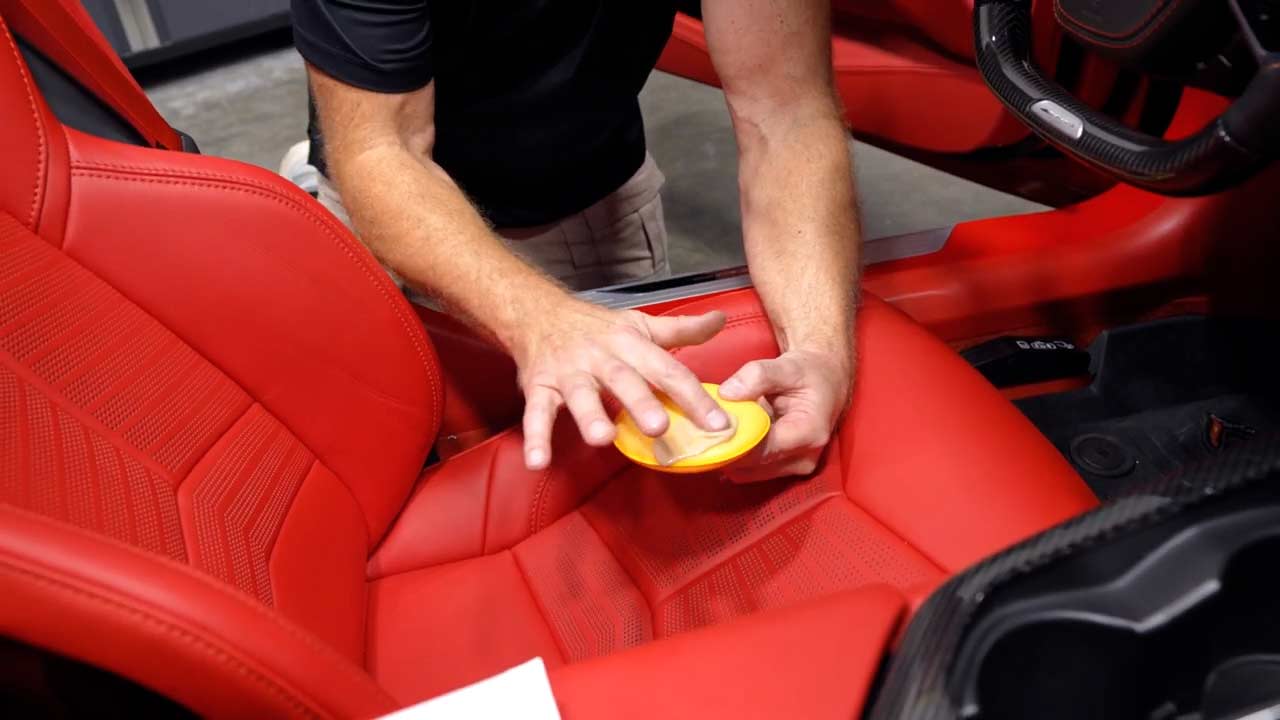 Applying leather conditioner to a yellow applicator pad