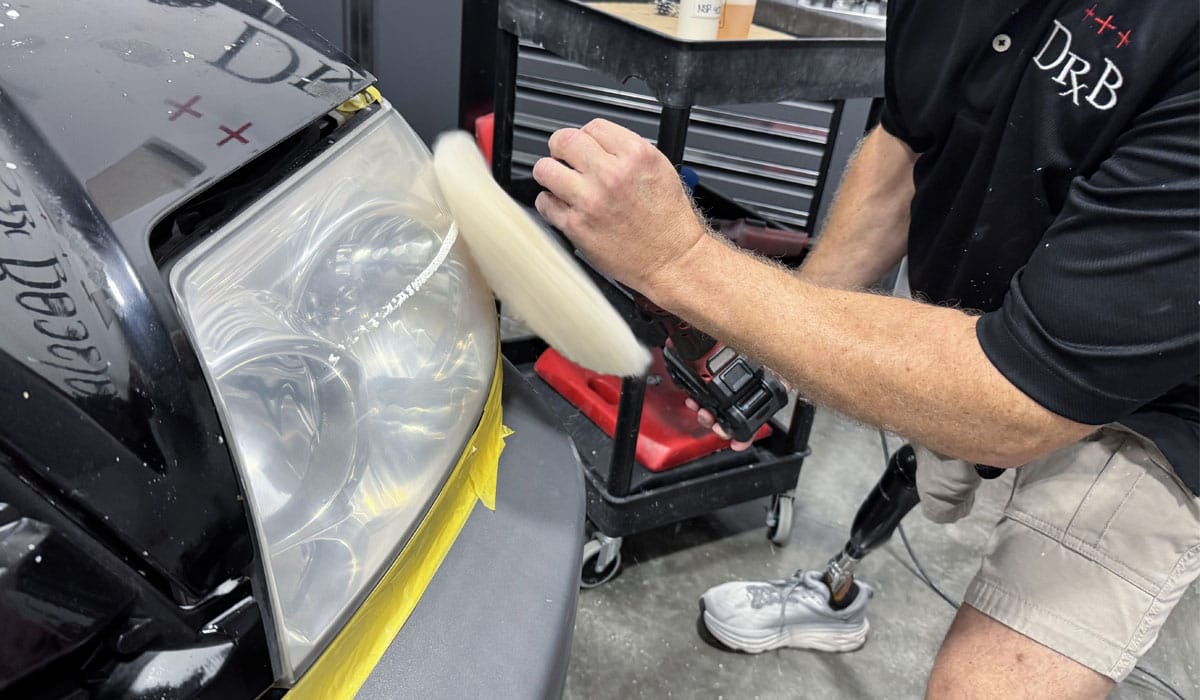 Buffing headlights with wool pad on rotary polisher to remove sanding marks