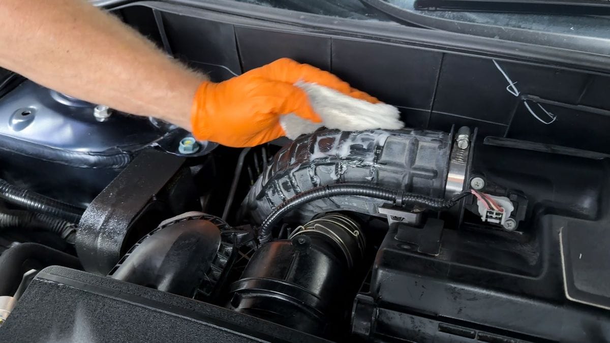 Applying plastic sealant to engine bay