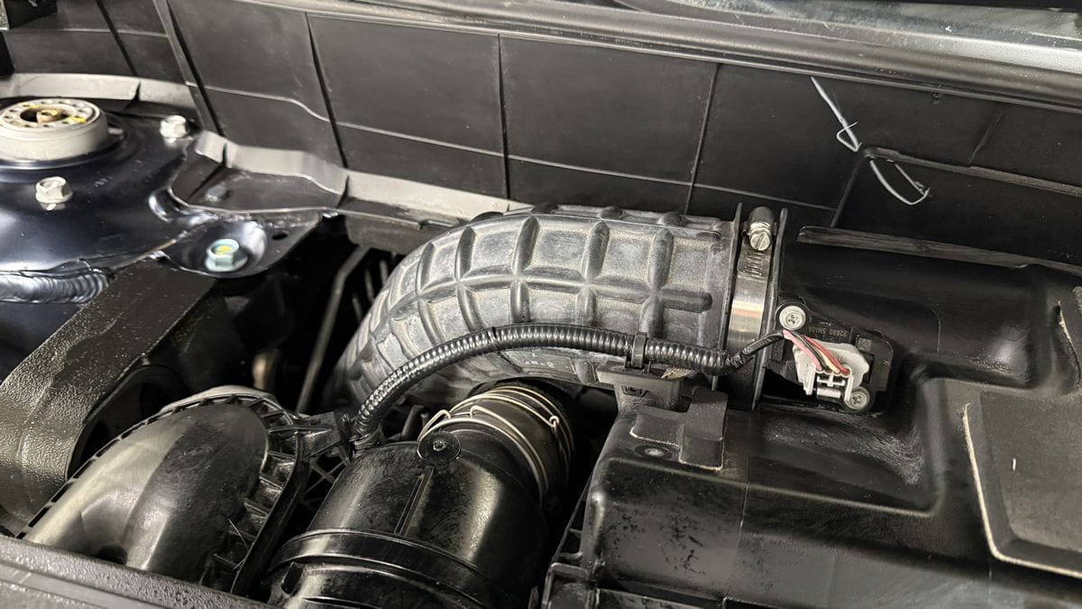 Applying plastic sealant to engine bay