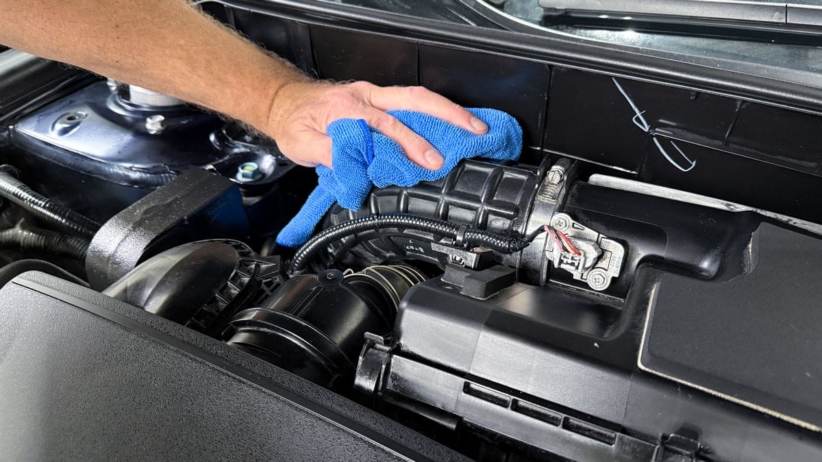 Applying plastic sealant to engine bay