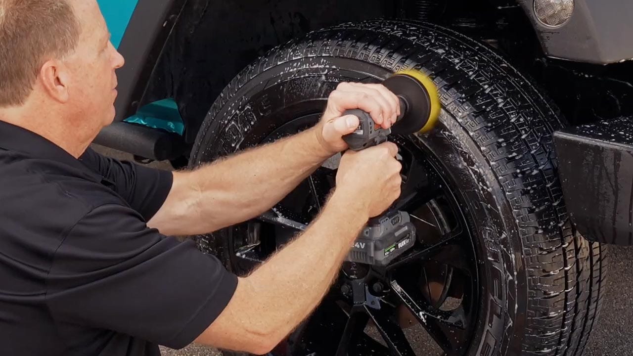 Machine power scrubbing a tire