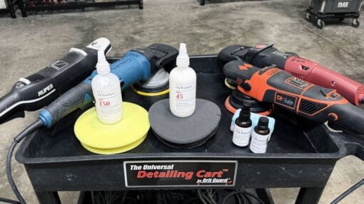 Machine polishers, polishing pads, Dr. Beasley’s NSP products, and coating bottles arranged on a detailing cart.