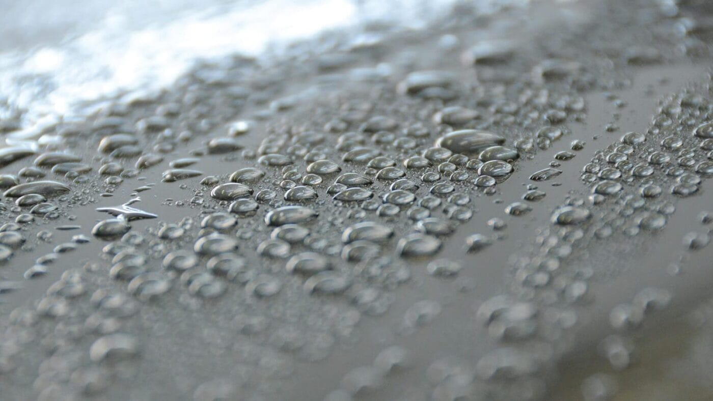 Water droplets beading on ceramic-coated car paint before touchless drying